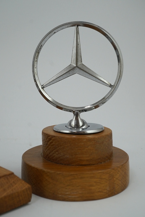 Four car mascots including; a 1920s Alvis eagle mascot designed by Charles Paillet, a Mercedes-Benz mascot, and two Jaguar mascots of different sizes, all mounted on oak bases. Condition - fair to good